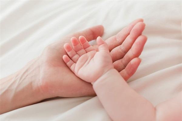 trẻ sơ sinh nắm chặt tay khi ngủ